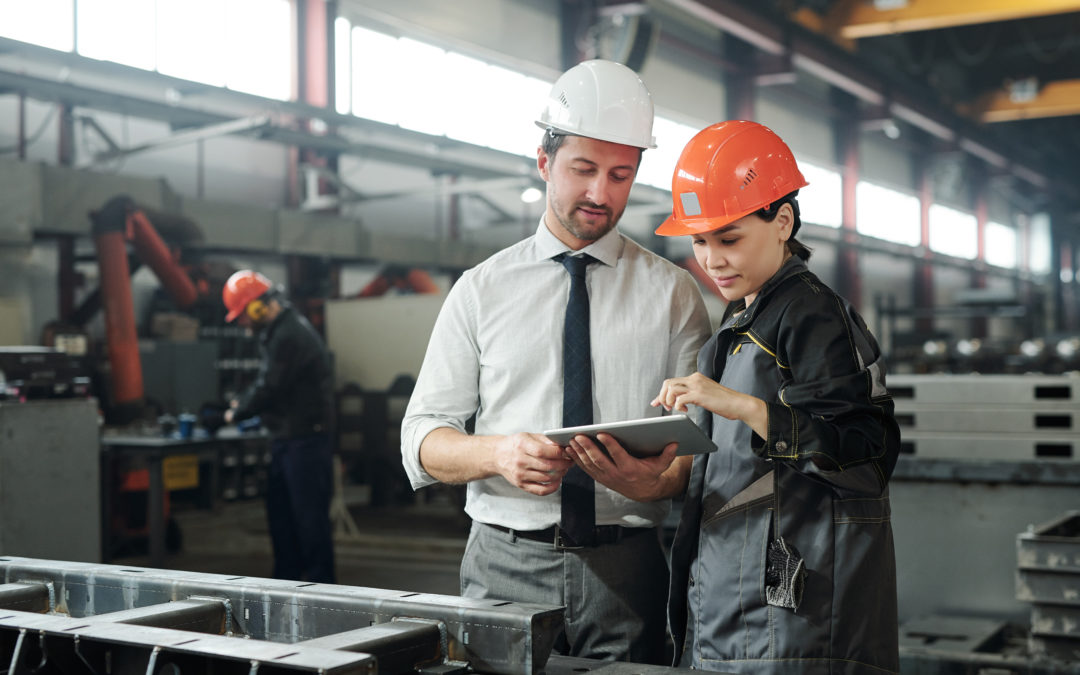 two engineers looking at a tablet discussing the process of a mechanics job