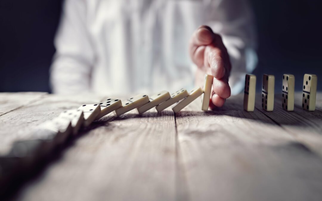 hand stopping the domino effect to signify the concept of business continuity